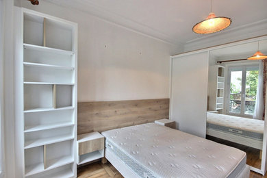 Inspiration pour une chambre parentale blanche et bois nordique de taille moyenne avec un mur blanc, un sol en bois brun et dressing.