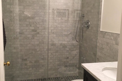 Example of a transitional gray tile and white tile white floor bathroom design in New York with flat-panel cabinets, dark wood cabinets, white walls, a drop-in sink and quartz countertops