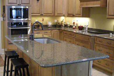 Eat-in kitchen - mid-sized traditional l-shaped eat-in kitchen idea in Atlanta with an undermount sink, raised-panel cabinets, dark wood cabinets, granite countertops, stainless steel appliances and an island