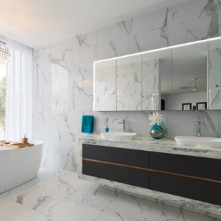 Inspiration for a contemporary bathroom in Gold Coast - Tweed with a freestanding tub, white tile, white walls, marble benchtops, black floor, a double vanity and a floating vanity.