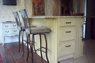 Eat-in kitchen - eat-in kitchen idea in Cleveland with flat-panel cabinets, beige cabinets, granite countertops, beige backsplash and an island