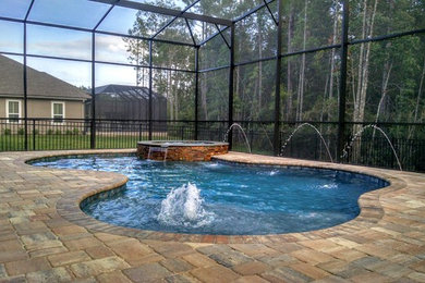 Inspiration for a mid-sized country backyard custom-shaped pool in Jacksonville with concrete pavers.