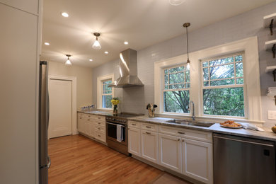 Kitchen - mid-sized traditional galley light wood floor and brown floor kitchen idea in Atlanta with a double-bowl sink, shaker cabinets, white cabinets, granite countertops, blue backsplash, ceramic backsplash, stainless steel appliances and gray countertops