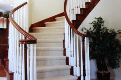 Photo of a large traditional carpeted curved staircase in San Francisco with carpet risers.