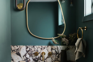 Réalisation d'un WC et toilettes bohème avec un mur vert, un lavabo encastré, un plan de toilette multicolore et meuble-lavabo suspendu.