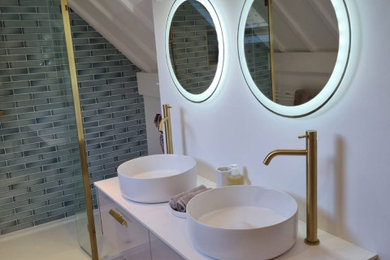 Design ideas for a contemporary bathroom in West Midlands with flat-panel cabinets, a freestanding bath, engineered stone worktops, an open shower and double sinks.