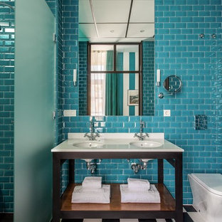 Modelo de cuarto de baño principal, marinero, de tamaño medio, con armarios abiertos, bañera empotrada, combinación de ducha y bañera, sanitario de una pieza, baldosas y/o azulejos azules, paredes azules, lavabo bajoencimera, puertas de armario negras y baldosas y/o azulejos de cemento