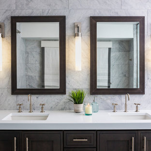 Bathroom - large transitional master gray tile and marble tile porcelain floor and gray floor bathroom idea in Denver with recessed-panel cabinets, dark wood cabinets, an urinal, white walls, an undermount sink, quartz countertops, a hinged shower door and white countertops