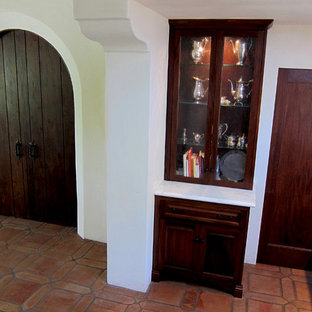 Неиссякаемый источник вдохновения для домашнего уюта: маленькая угловая кухня в средиземноморском стиле с обеденным столом, врезной раковиной, фасадами с выступающей филенкой, мраморной столешницей, белым фартуком, черной техникой, полом из терракотовой плитки, темными деревянными фасадами, фартуком из плитки кабанчик, красным полом и белой столешницей без острова