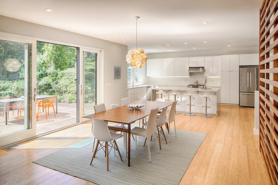 Inspiration for a mid-sized contemporary medium tone wood floor and brown floor great room remodel in Boston with gray walls and no fireplace