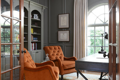 Example of a large classic freestanding desk medium tone wood floor home office design in Houston with gray walls