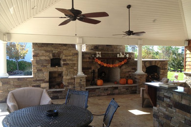 Inspiration for a large timeless backyard stone patio remodel in New York with a fire pit and a gazebo