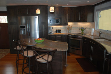 Eat-in kitchen - mid-sized mediterranean single-wall light wood floor eat-in kitchen idea in Denver with a single-bowl sink, shaker cabinets, beige cabinets, laminate countertops, beige backsplash, stainless steel appliances, two islands and stone tile backsplash