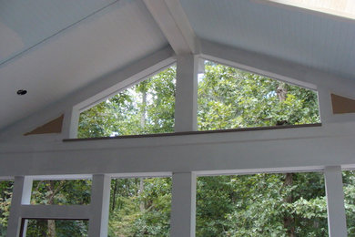Mid-sized elegant screened-in back porch photo in Raleigh with a roof extension