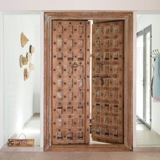 Diseño de puerta principal mediterránea con paredes blancas, puerta doble y puerta de madera en tonos medios