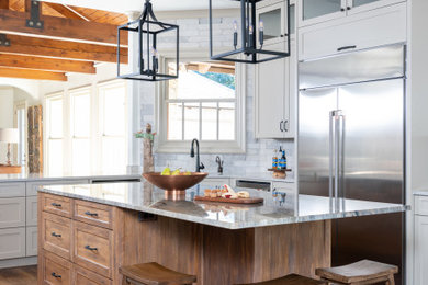 Inspiration for a large transitional dark wood floor, brown floor and exposed beam eat-in kitchen remodel in Other with shaker cabinets, distressed cabinets, quartzite countertops, gray backsplash, ceramic backsplash, stainless steel appliances and an island