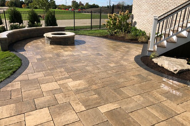 Mid-sized country backyard patio in Chicago with natural stone pavers.