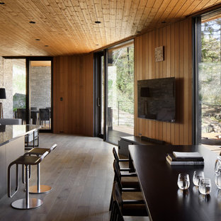 Idéer för funkis allrum med öppen planlösning, med bruna väggar, plywoodgolv, en väggmonterad TV och grått golv