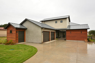 Inspiration for a large contemporary gray two-story stucco gable roof remodel in Austin