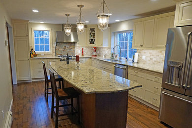 Kitchen pantry - large transitional l-shaped medium tone wood floor kitchen pantry idea in Boston with an undermount sink, beaded inset cabinets, beige cabinets, quartz countertops, beige backsplash, stone tile backsplash, stainless steel appliances and an island