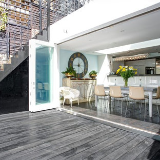 This is an example of a contemporary open plan kitchen in London with dark hardwood flooring.