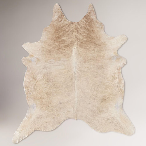 Hanging cowhide rug behind bed
