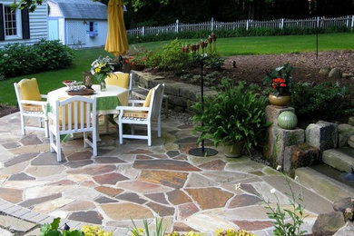 Inspiration for a mid-sized rustic backyard stone patio remodel in Cleveland with no cover