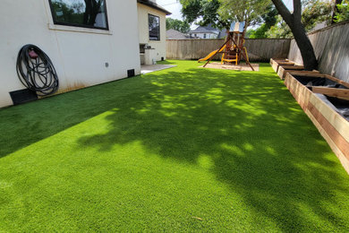 Ejemplo de jardín minimalista de tamaño medio en verano en patio trasero con parque infantil y exposición parcial al sol