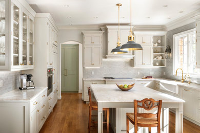 Large farmhouse u-shaped light wood floor and brown floor eat-in kitchen photo in Raleigh with a farmhouse sink, beaded inset cabinets, beige cabinets, quartzite countertops, beige backsplash, ceramic backsplash, stainless steel appliances, an island and beige countertops