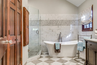Large traditional master bathroom in Dallas with recessed-panel cabinets, dark wood cabinets, a freestanding tub, a corner shower, gray tile, marble, grey walls, marble floors, an undermount sink, marble benchtops, multi-coloured floor, a hinged shower door and grey benchtops.
