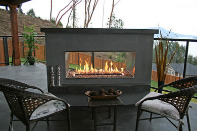 Mid-sized classic concrete back porch idea in Vancouver with a fire pit and a roof extension