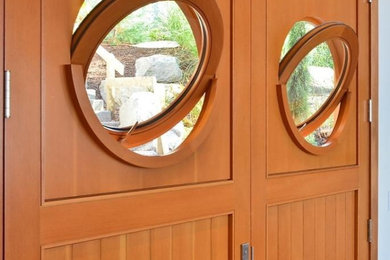 This is an example of a small beach style front door in Seattle with a double front door and a medium wood front door.