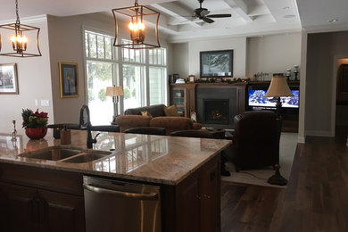 Living room - transitional open concept dark wood floor and brown floor living room idea in Cedar Rapids with beige walls, a standard fireplace, a stone fireplace and a media wall