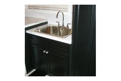 Design ideas for a small galley separated utility room in Toronto with a single-bowl sink, recessed-panel cabinets, black cabinets, quartz worktops, white walls, ceramic flooring and a side by side washer and dryer.