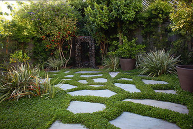 Photo of a mid-sized traditional partial sun backyard stone landscaping in Austin.
