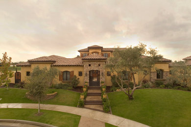 Huge tuscan yellow two-story house exterior photo in Other with a hip roof and a brown roof