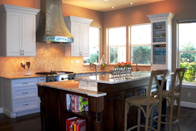 Inspiration for a large transitional l-shaped dark wood floor and brown floor eat-in kitchen remodel in San Francisco with a farmhouse sink, recessed-panel cabinets, white cabinets, quartzite countertops, beige backsplash, ceramic backsplash, stainless steel appliances and an island