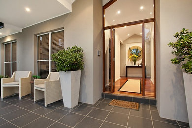 Photo of a mid-sized transitional front door in Newcastle - Maitland with medium hardwood floors, a single front door, a medium wood front door and white walls.