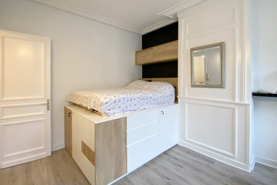 Cette photo montre une petite chambre blanche et bois tendance avec un mur blanc, parquet clair, une cheminée standard, un sol gris et boiseries.