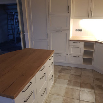 schicke Landhausküche mit Arbeitsinsel und stylischem Fliesenspiegel