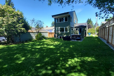 Inspiration for a mid-sized transitional green two-story concrete fiberboard exterior home remodel in Seattle with a shingle roof
