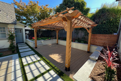Large 1950s backyard ground level deck photo in Other with a pergola