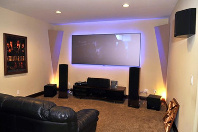 Mid-sized trendy enclosed carpeted home theater photo in Columbus with beige walls and a projector screen