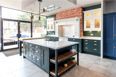 This is an example of a mid-sized kitchen in London with with island.
