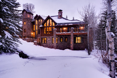 Inspiration for a large contemporary gray three-story stone house exterior remodel in Denver with a hip roof and a shingle roof