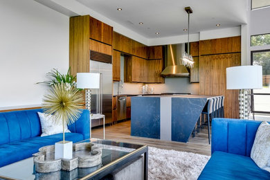 Trendy l-shaped light wood floor kitchen photo in Austin with flat-panel cabinets, stainless steel appliances and an island