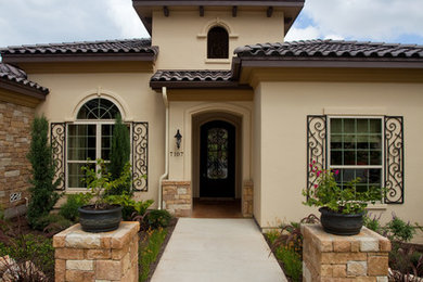 Inspiration for a mid-sized mediterranean beige one-story mixed siding exterior home remodel in Austin with a hip roof