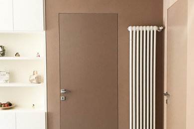 Ispirazione per un ingresso minimal di medie dimensioni con pareti marroni, pavimento in gres porcellanato e pavimento beige