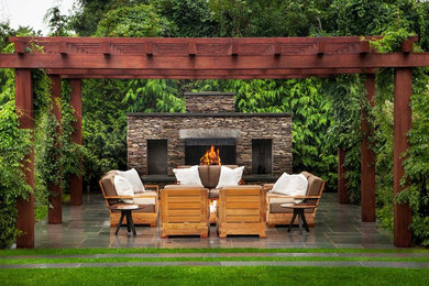 Design ideas for a transitional patio in New York with tile, a pergola and with fireplace.
