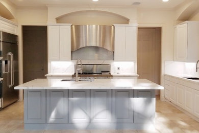 Photo of a large transitional single-wall separate kitchen in Houston with a double-bowl sink, beaded inset cabinets, white cabinets, marble benchtops, white splashback, marble splashback, stainless steel appliances, ceramic floors, with island and white benchtop.